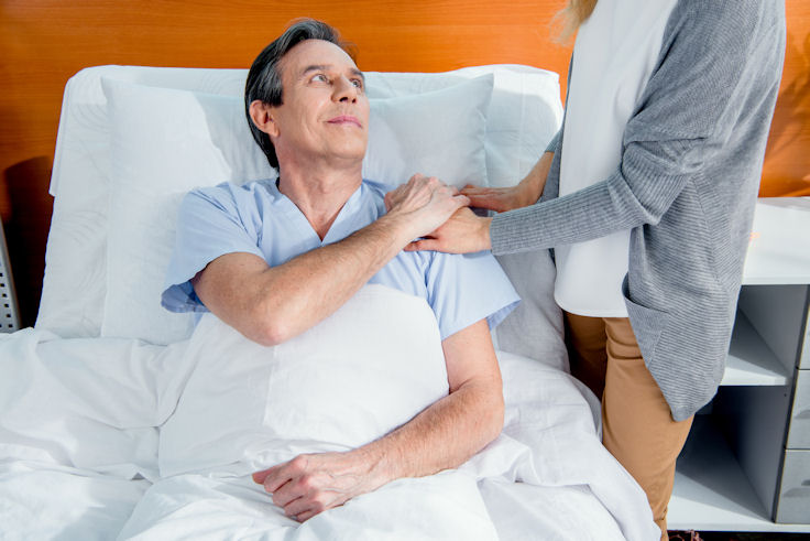 Man in hospital bed with visitor