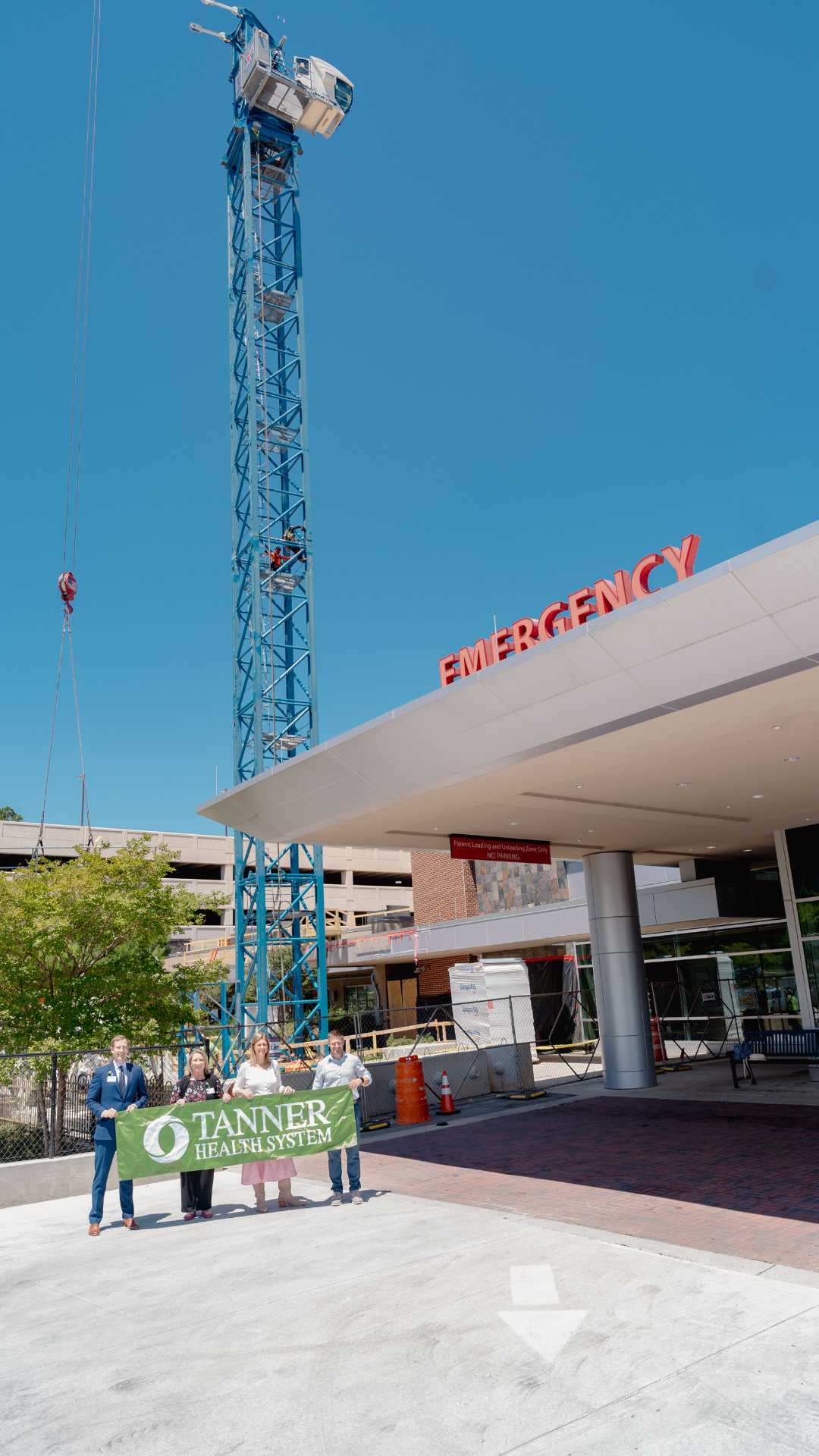 Tanner leadership with Tanner Health System banner for tower crane at Tanner Medical Center/Carrollton